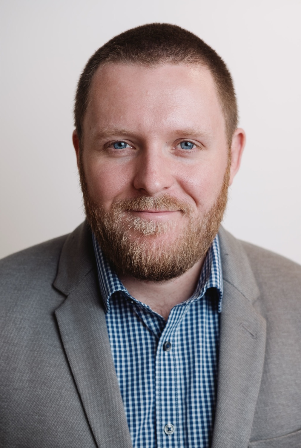 Team headshot in a grey jacket, consistent studio setup, London