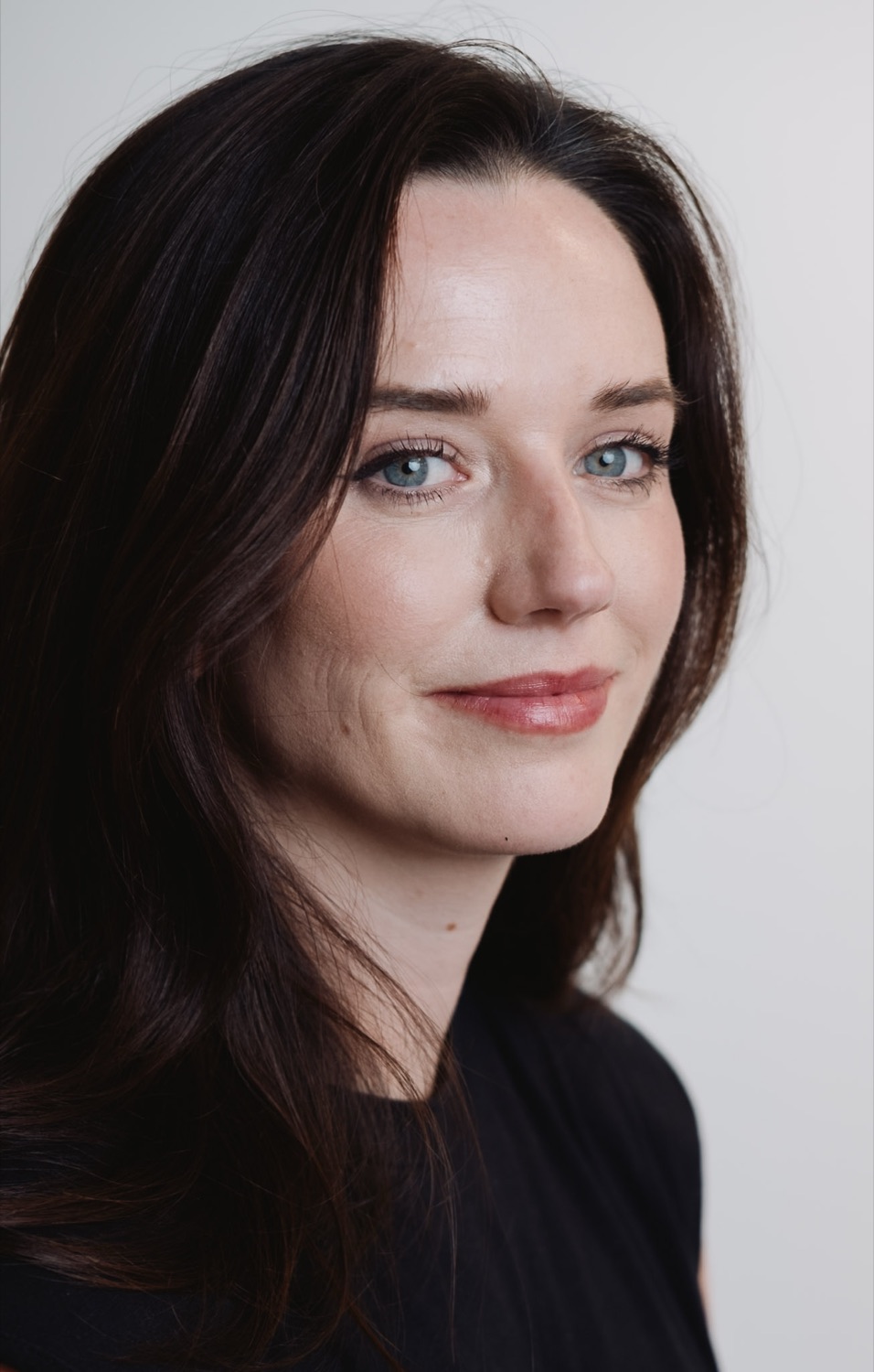 Editorial-style corporate portrait, soft neutral backdrop, London